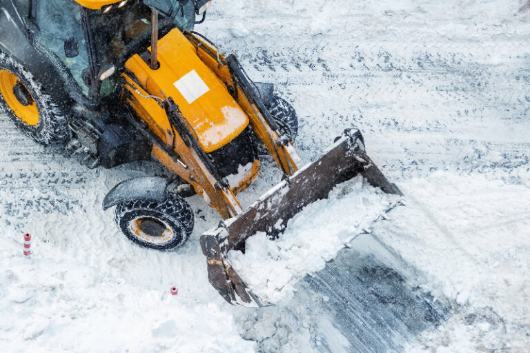loader pushing snow on covered ground