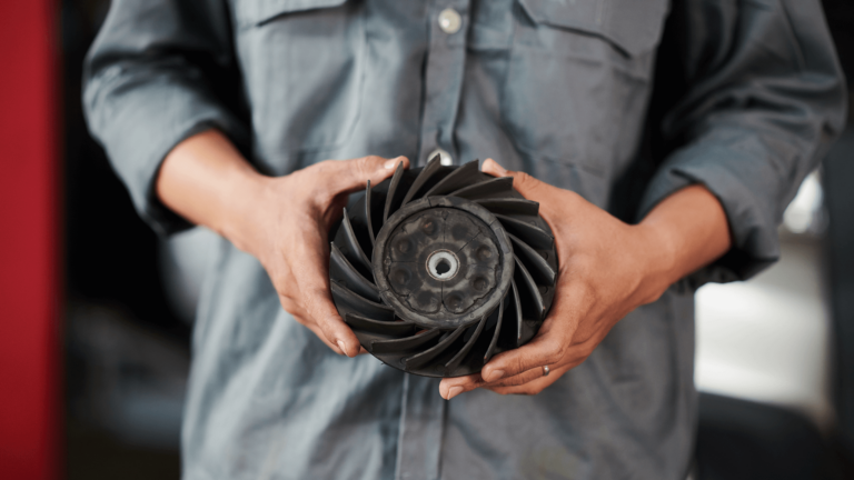 man in a gray shirt holding a fan clutch